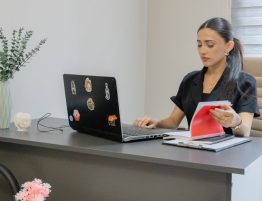 Woman working on a laptop at a desk.