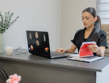 Woman working on a laptop at a desk.
