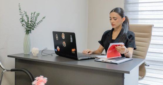 Woman working on a laptop at a desk.